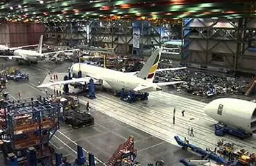 an airplane hangar with workers in the background